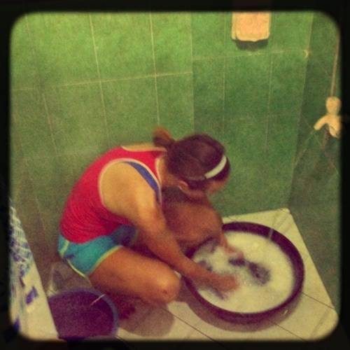 Woman washing clothes in a tub.