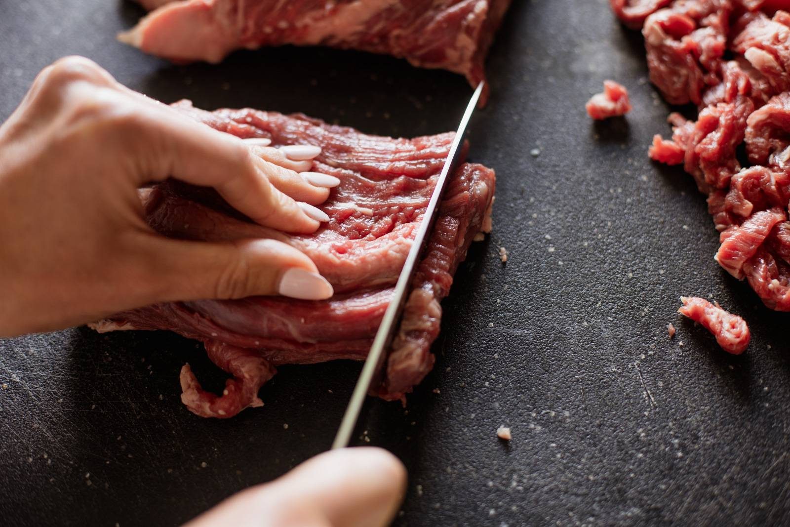 Cutting steak into strips.