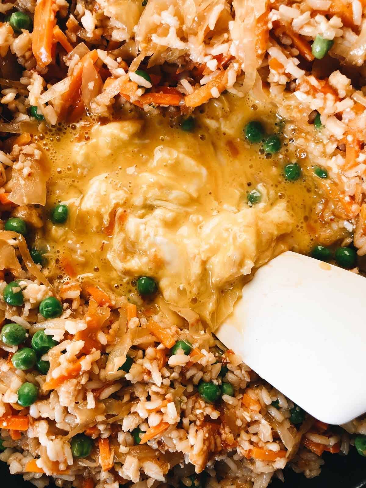Scrambling egg in kimchi fried rice.