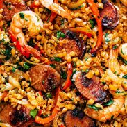 Cauliflower rice and meats arranged together on a sheet pan.